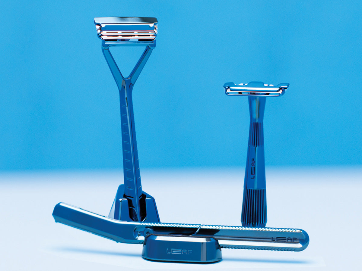 Three blue razors set against a blue background