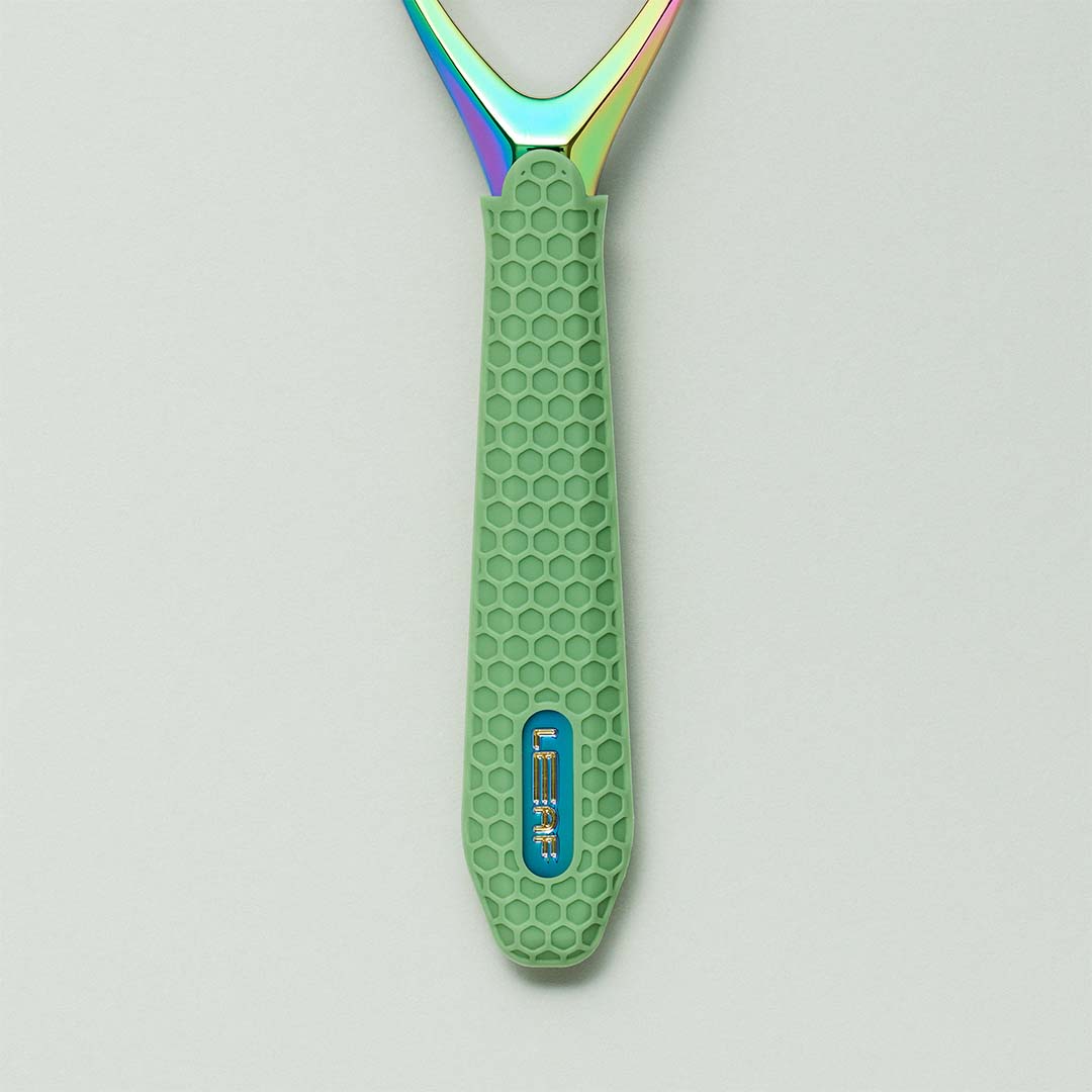 Green grooming tool with a textured handle and colorful head on a light gray background