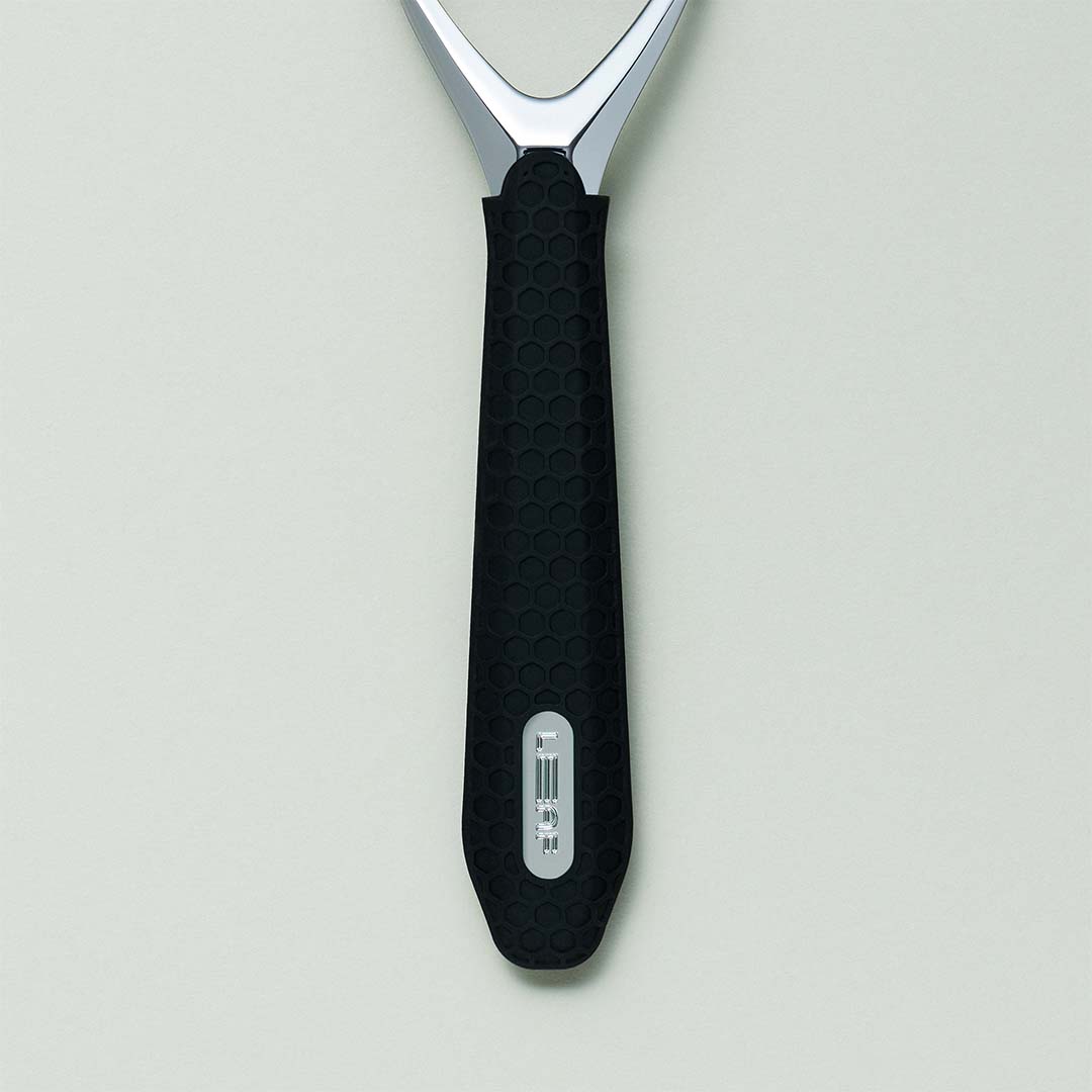 Spatula with black handle and silver head on a light gray background
