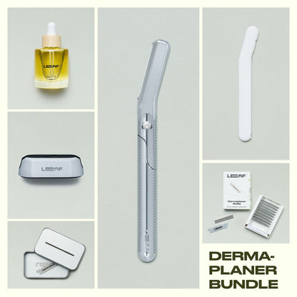 Leaf Shave Dermaplaner bundle in chrome finish including handle, refill blades packaging, stand, white travel cover, recycling tin, and glass shave oil bottle on grey background