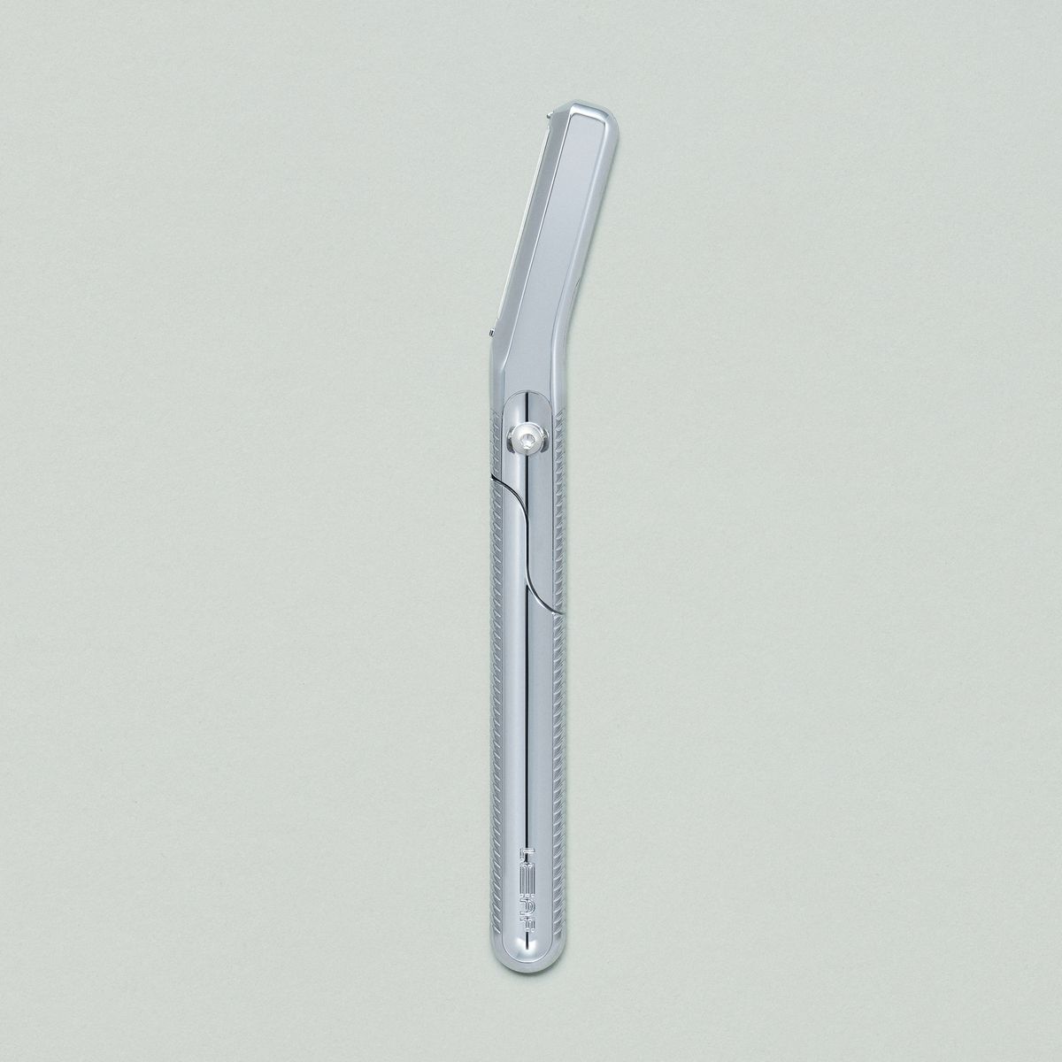 Chrome dermaplaner on grey background