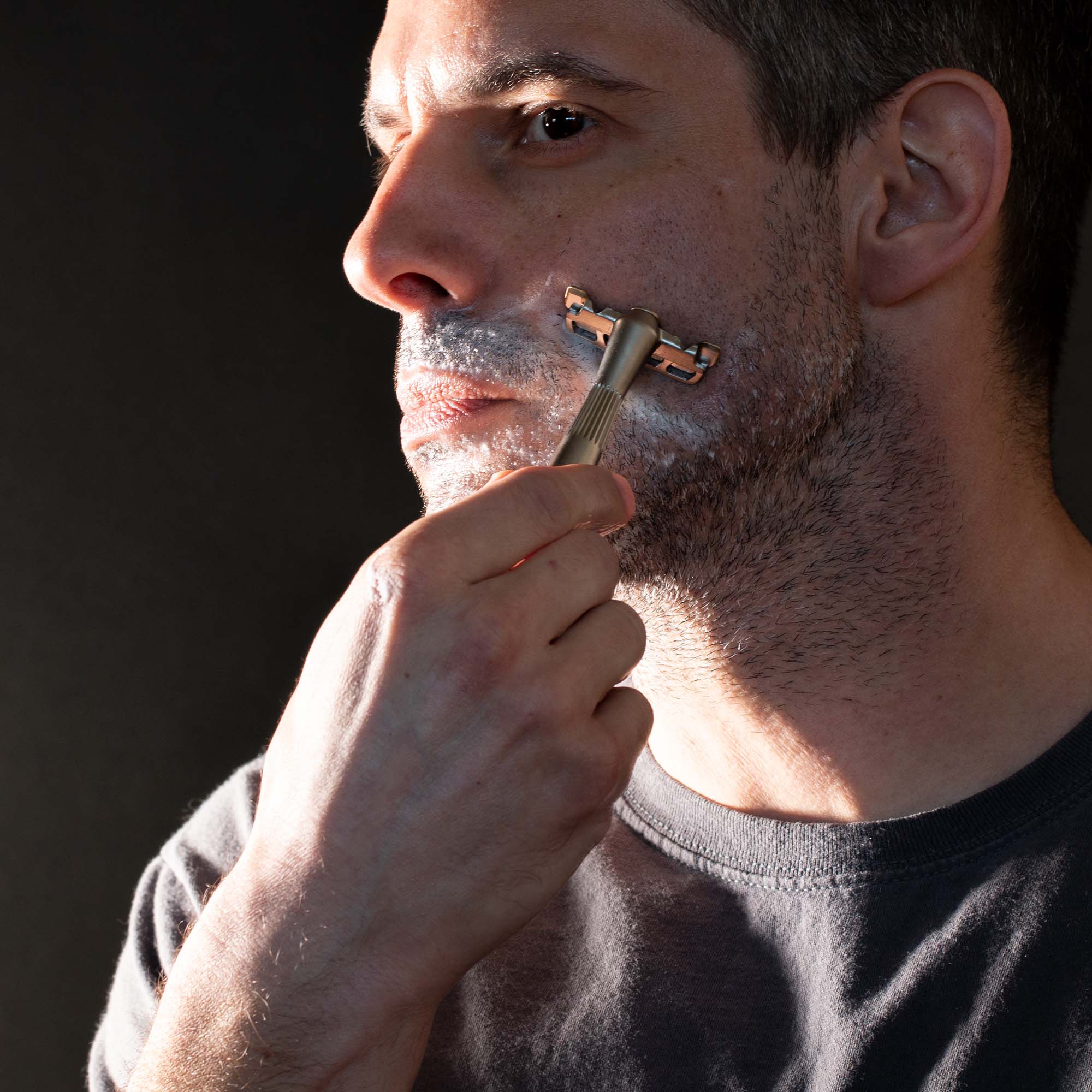 Person shaving their scruffy face with a Leaf single-edge razor.