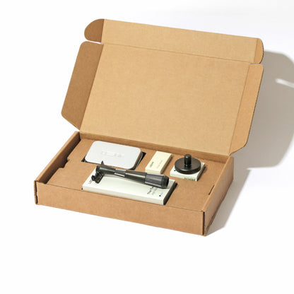 A kraft box on white, open, with a single-edge razor kit displayed in the finish called Black