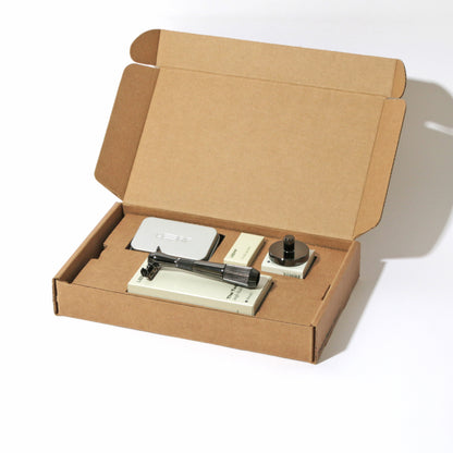 A kraft box on white, open, with a single-edge razor kit displayed in the finish called Mercury