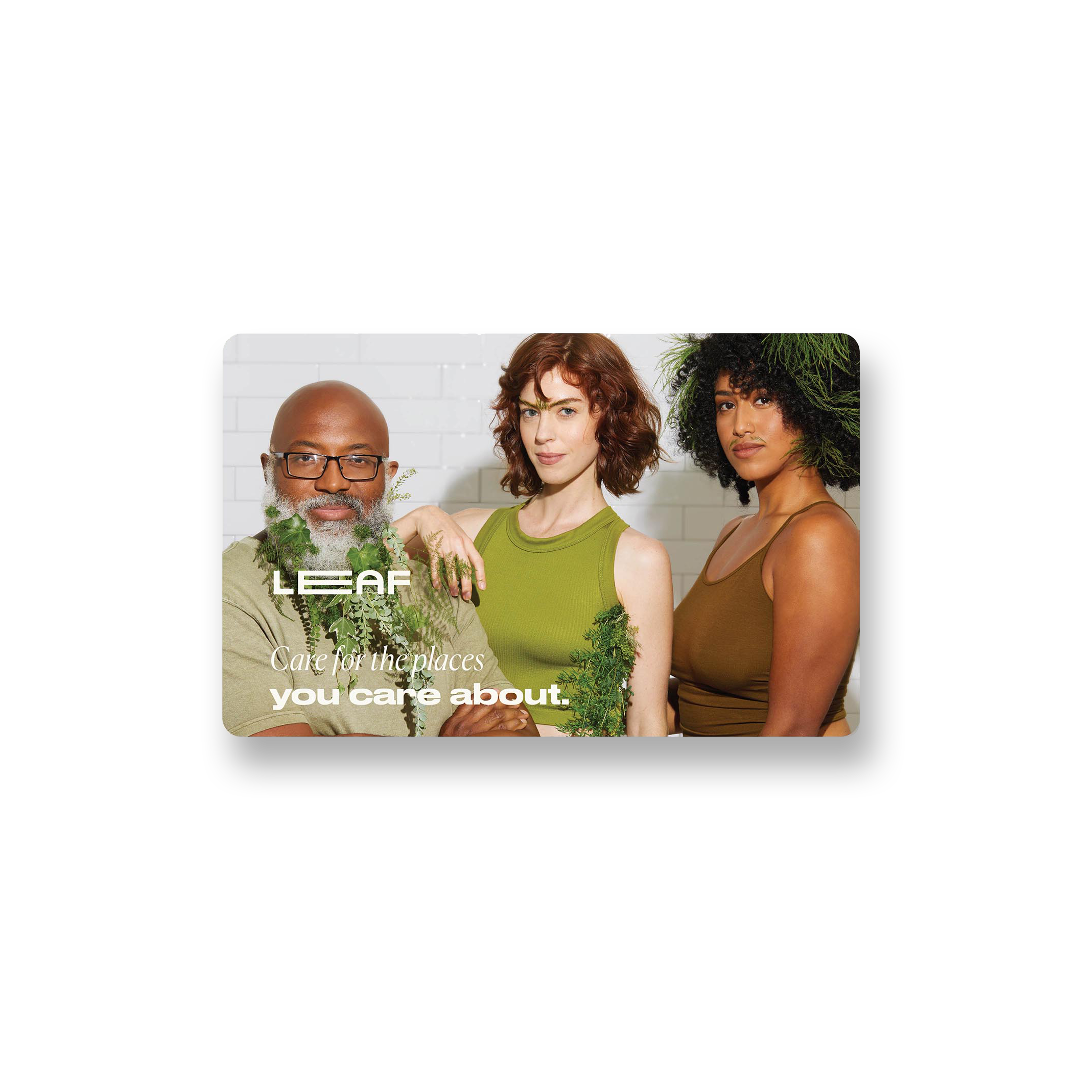 A photo of a rectangular gift card, with three models standing shoulder to shoulder whose hair has been stylized using leafs and plants. The text on the gift card reads: "Care for the places you care about," and there is a Leaf logo on the card as well."